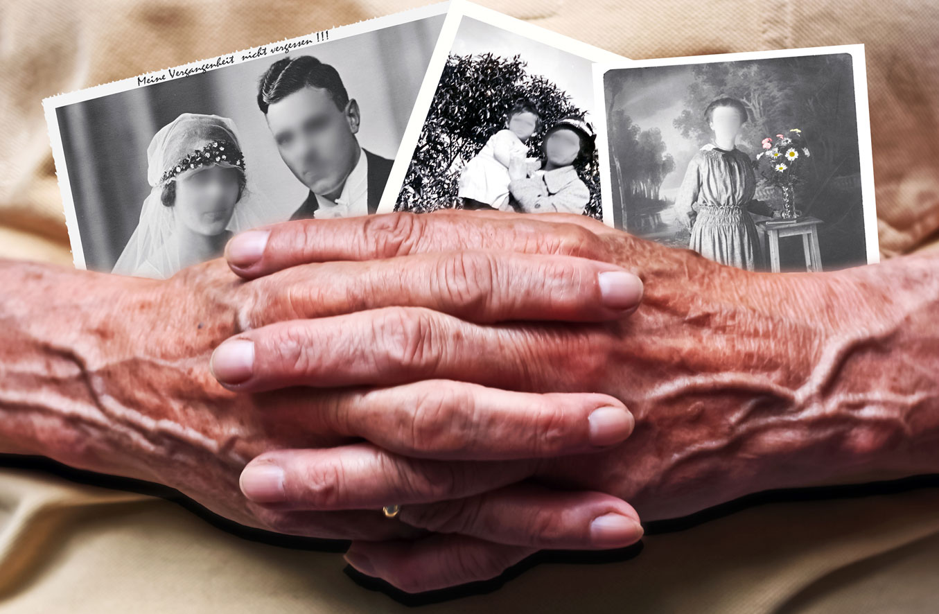 Old ladies hands holding photos with the faces blurred out